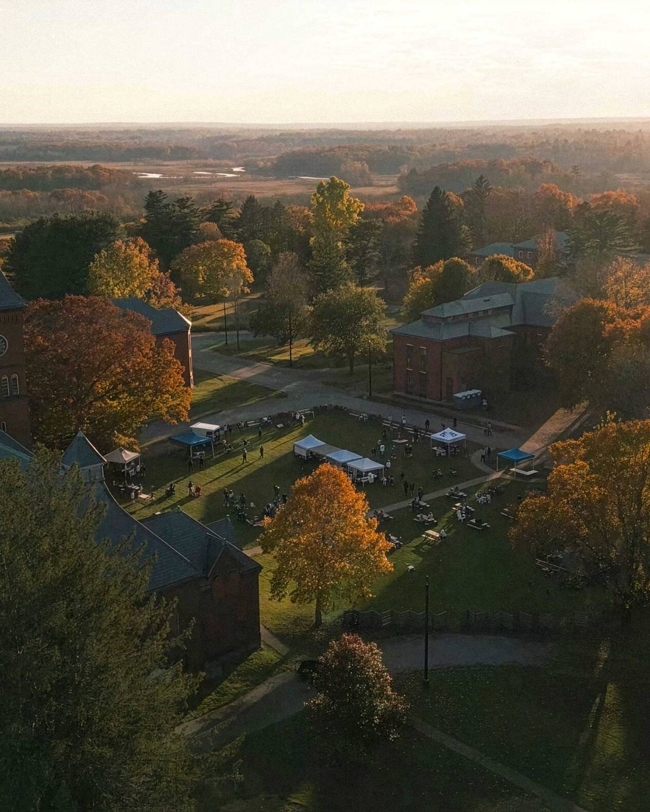Aerial view of the Bellforge Arts Center campus at sunset, showing the Lee Chapel and Infirmary among autumn trees