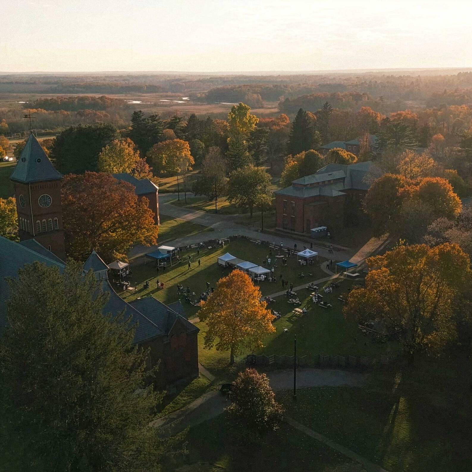 Aerial view of the Bellforge Arts Center campus at sunset, showing the Lee Chapel and Infirmary among autumn trees