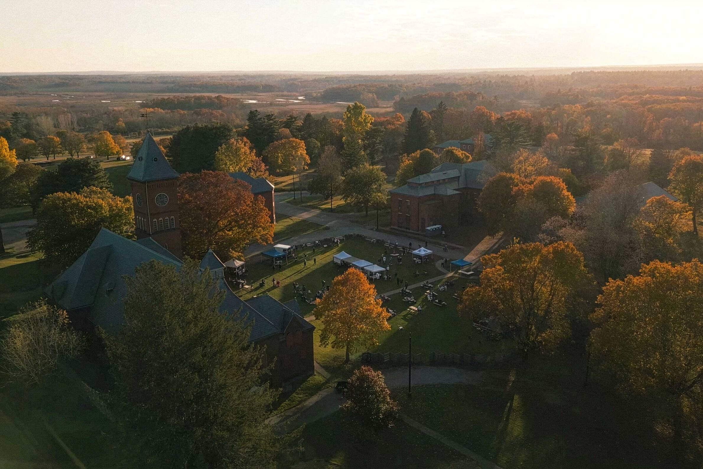 Aerial view of the Bellforge Arts Center campus at sunset, showing the Lee Chapel and Infirmary among autumn trees